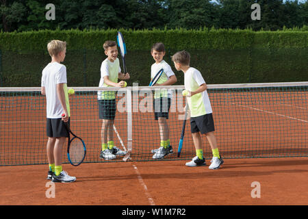 Young boys playing tennis on a sunny day, Bavaria, Germany Stock Photo