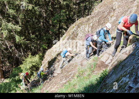 Climbing group scaling rock face via ferrata towards Stuibenfall Waterfall, Otztal, Tyrol, Austria Stock Photo