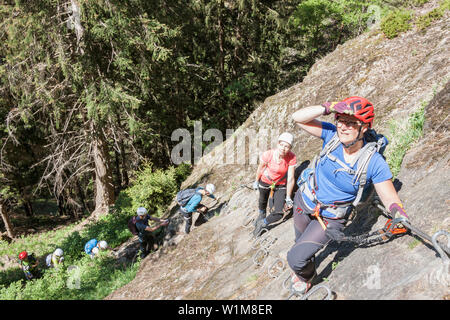 Climbing group scaling rock face via ferrata towards Stuibenfall Waterfall, Otztal, Tyrol, Austria Stock Photo