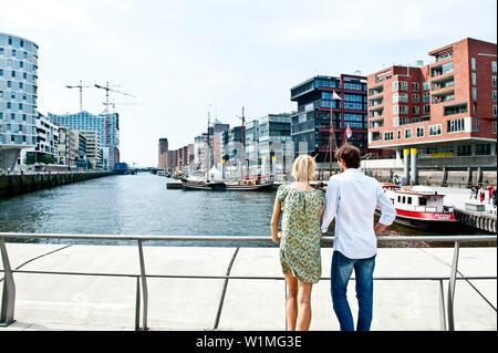 Couple looking over harbor basin, Magellan-Terraces, HafenCity, Hamburg, Germany Stock Photo