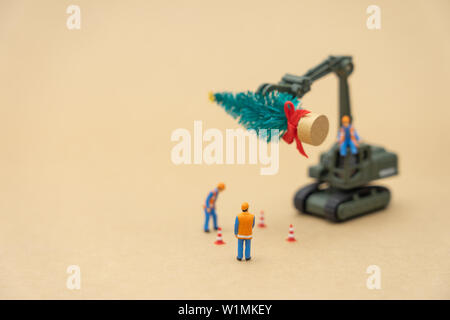 Miniature people Construction worker standing on Christmas tree Celebrate Christmas on December 25 every year. using as background xmas concept with c Stock Photo