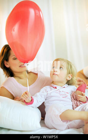 Toddler girl holding red balloon Stock Photo