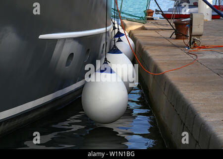 Mooring fender hangs on a boat, close-up. Stock Photo