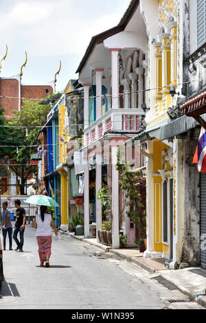 woman with umbrella on the street in old town of Phuket, Thailand Stock Photo