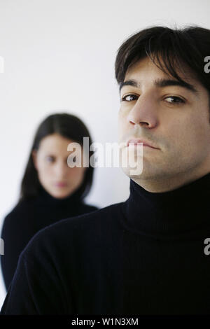 Serious man looking at camera, woman standing in background, Vienna, Austria Stock Photo