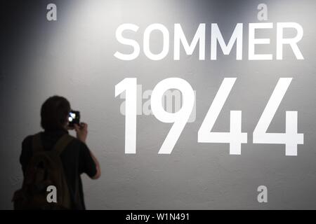 03 July 2019, Saxony, Dresden: A journalist photographs the stroke 'Sommer 1944' in the exhibition 'Der Führer Adolf Hitler ist tot' at the Militärhistorisches Museum Dresden. The exhibition (04 July to 03 December 2019) is dedicated to the prehistory, course and consequences of the bomb attack on Hitler by Claus Schenk Graf von Stauffenberg. Photo: Sebastian Kahnert/dpa-Zentralbild/dpa Stock Photo