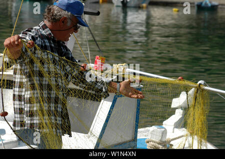 Fisherman recovering his net, Port of Vathi, Kalymnos, Greece Stock Photo
