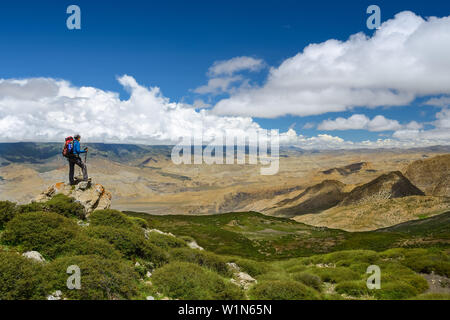Young woman, trekker at an unnamed pass on her way from Nar over Teri Tal to Mustang from which the views are open onto Mustang with its villages in t Stock Photo