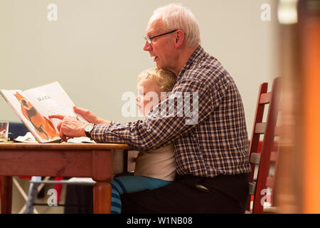 Grandfather reading a book to grandson, Leipzig, Saxony, Germany Stock Photo