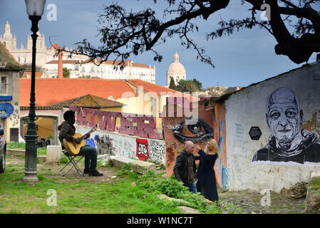 Wall paintings and musician in the Alfama, Lisbon, Portugal Stock Photo