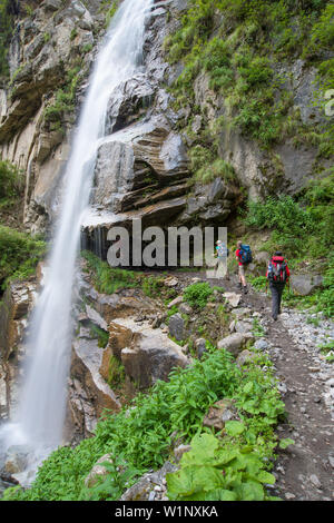 Two young women and a young man walking behind a waterfall on the Nar Phu Trek, Nepal, Himalaya, Asia Stock Photo