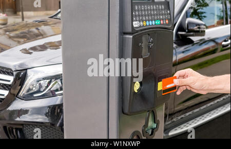 Man hand is paying his parking using credit card at parking pay station terminal Stock Photo