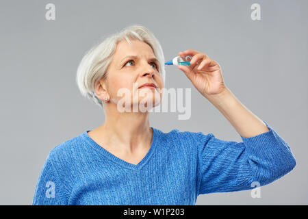 senior woman with dry eye syndrome using drops Stock Photo