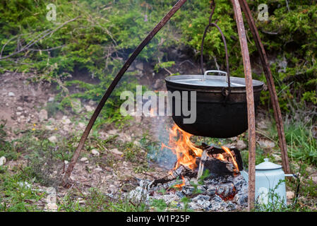 Cauldron or camping kettle over open fire outdoors Stock Photo - Alamy
