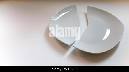 Two pieces of the broken white plate isolated on the white background Stock Photo