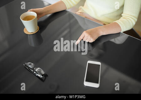 woman with coffee using black interactive panel Stock Photo