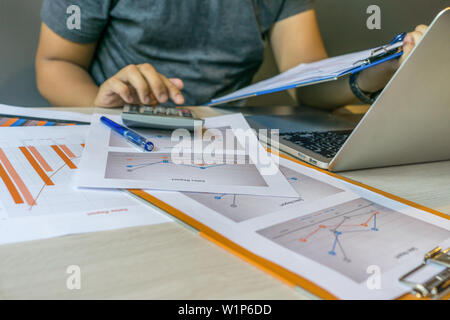 Close up of human hands using calculator , holding document Stock Photo