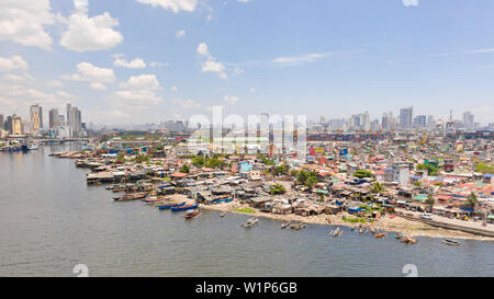 The urban landscape of Manila, with slums and skyscrapers. Sea port and residential areas. The contrast of poor and rich areas. The capital of the Philippines, view from above. Stock Photo