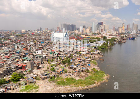 The urban landscape of Manila, with slums and skyscrapers. Sea port and residential areas. The contrast of poor and rich areas. The capital of the Philippines, view from above. Stock Photo