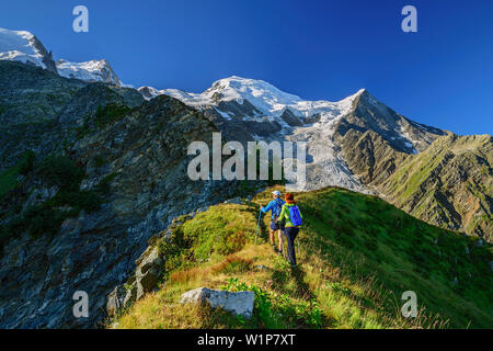 A man and a woman rise above pointed back to the pyramid on, Mont Blanc in the background, pyramid, Mont Blanc, Grajische Alps, the Savoy Alps, Savoie Stock Photo