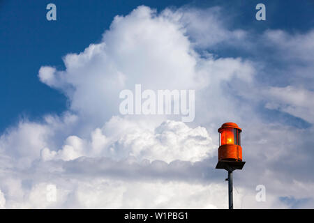 Storm warning light on the Chiemsee in Prien, behind white clouds in the blue sky Stock Photo