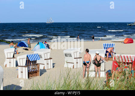 People and beach chairs on the beach, three-master in the background, Bansin, Usedom, Baltic Sea coast, Mecklenburg-Vorpommern, Germany Stock Photo