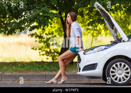 Young woman in trouble calling for help at the broken car Stock Photo