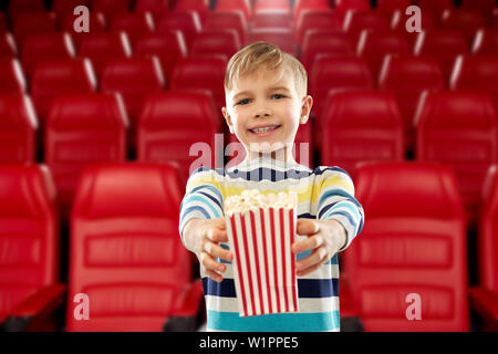 boy with paper bucket of popcorn at movie theater Stock Photo