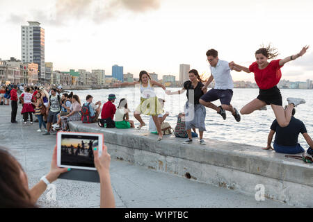 tourists and local people and fisherman at Malecon, woman taking pictures with tablet, historic town, center, old town, Habana Vieja, Habana Centro, f Stock Photo