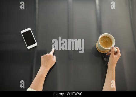 woman with coffee using black interactive panel Stock Photo