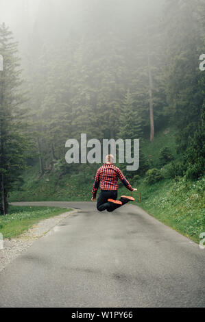 Man jumping on a street in Brandnertal, Vorarlberg, austria, europe. Stock Photo