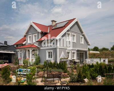 Gray two-story single family house with one dormer and a red roof in Nordic style with wooden facade, Korbach, Hesse, Germany, Europe Stock Photo