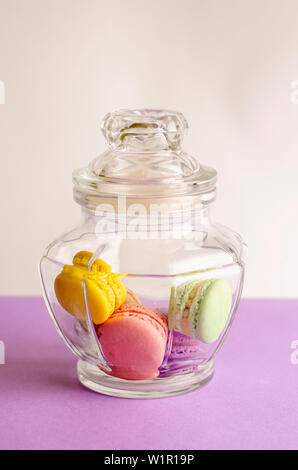 Glass jar with colorful macaroons. Vertical. Dessert concept. Stock Photo