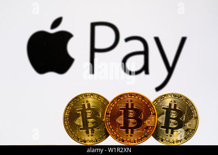 Gold Bitcoin coins with the Apple logo on background screen. A new type of business finance concept Stock Photo