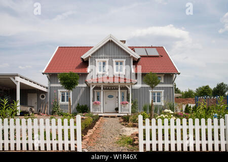 Gray two-story single family house with one dormer and a red roof in Nordic style with wooden facade, Korbach, Hesse, Germany, Europe Stock Photo