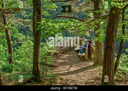 Man and woman sitting at vista-point in forest, Peterskanzel, Albsteig, Black Forest, Baden-Wuerttemberg, Germany Stock Photo