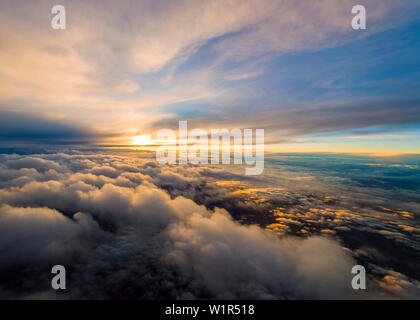 beautiful sunset during a flight between two cloud-layers Stock Photo