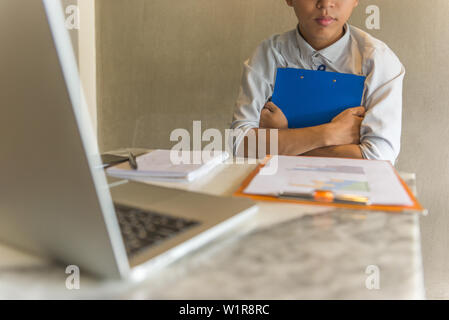 Young office staff holding folder in hands while working Stock Photo