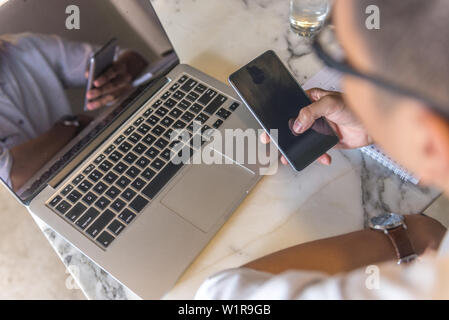 Rear view of young man using smart phone Stock Photo