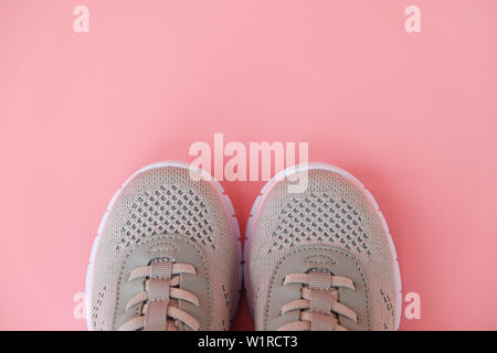 Sport, healthy lifestyle concept. New gray sneakers on pastel pink background. Copy space. Flat lay. Close-up. Stock Photo