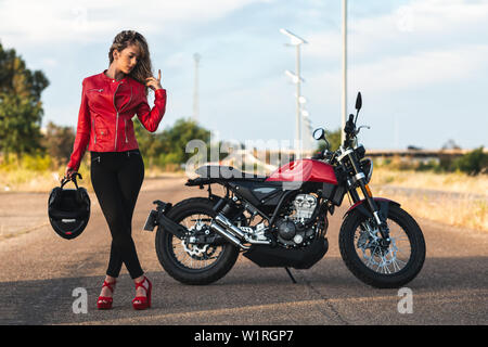 portrait of young  woman posing front classical motorbike. Stock Photo