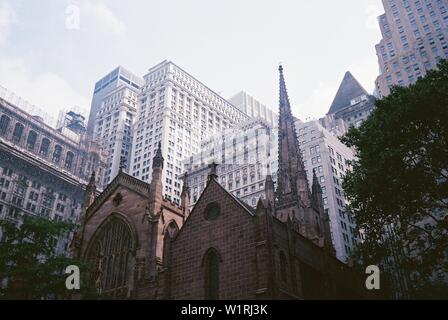 Low angle shot of the Trinity church in New York City with a clear white sky in the background Stock Photo