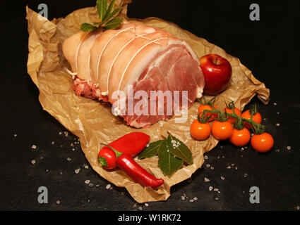 Rolled joint of raw Pork on Black background landscape. Stock Photo