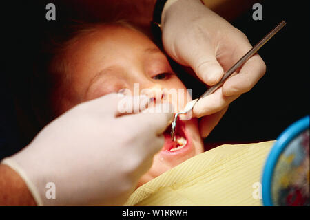  Young girl sitting in the dentist examination chair having her teeth examined