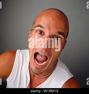 Bald headed man bulging eyes And open   Open mouth with pierced tongue Stock Photo