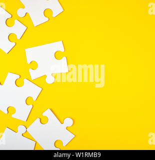 blank white big puzzles on yellow background, flat lay Stock Photo
