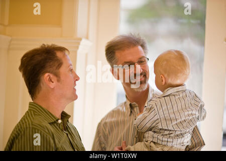 Two mid-adult men with a young toddler. Stock Photo