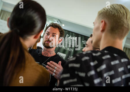 Berlin, Germany. 03rd July, 2019. Marcel Ostertag, designer, gives his models a few tips before the show. The collections for Spring/Summer 2020 will be presented at Berlin Fashion Week. Credit: Lisa Ducret/dpa/Alamy Live News Stock Photo