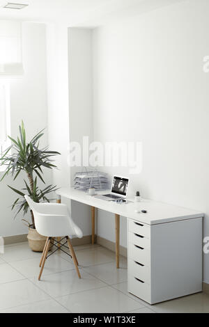 office table on which laptop, coffee, tablet, camera and other items Stock Photo