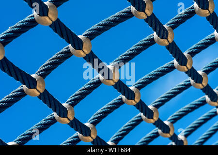 Bright blue rope mesh against a bright blue sky close-up. Background and texture Stock Photo